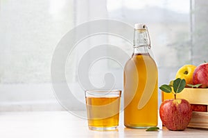 Healthy organic food. Apple cider vinegar or juice in glass bottle and fresh red apples
