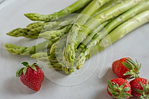 Healthy organic green fresh asparagus with a bunch of healthy strawberries