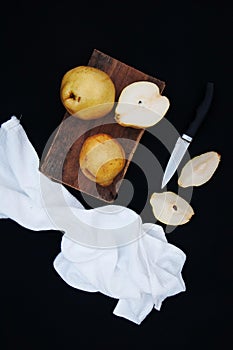 Healthy organic yellow pears on the desk. Fruit background. Ripe fresh organic pears on black background. Pear autumn harvest. Sli