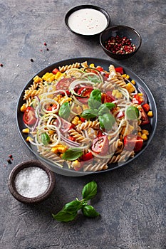 Healthy pasta salad with zucchini sweet corn tomato and basil, vegetarian lunch