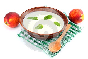 Healthy peach yogurt with peach gruit and mint leaves isolated on white background