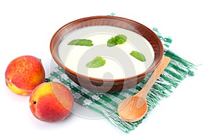 Healthy peach yogurt with peach gruit and mint leaves isolated on white background