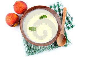 Healthy peach yogurt with peach gruit and mint leaves isolated on white background