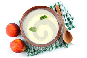 Healthy peach yogurt with peach gruit and mint leaves isolated on white background photo