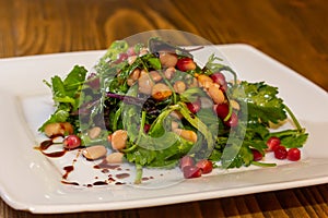 Healthy pearl barley salad with beans, cucumbers, red onion, sunflower seeds, pomegranate and parsley in bowl on