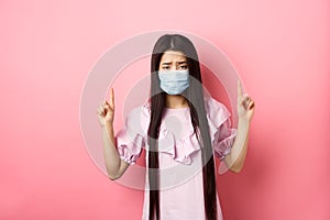 Healthy people and covid-19 pandemic concept. Sad asian girl feeling sick, wearing medical mask on self-quarantine