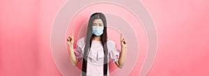 Healthy people and covid-19 pandemic concept. Sad asian girl feeling sick, wearing medical mask on self-quarantine