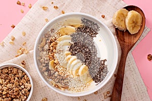 Healthy pineapple, mango smoothie bowl with coconut, bananas, blueberries and granola. Top view scene on a bright background