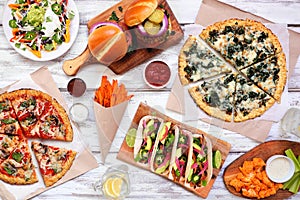 Healthy plant based fast food table scene. Above view on a white wood background.