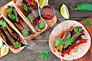 Healthy, plant-based meatless portobello mushroom steak fajitas, top view table scene on a wood background