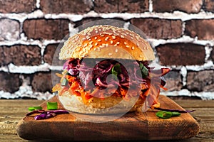 Healthy, plant based meatless pulled carrot burger against a dark brick background