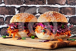 Healthy, plant based meatless pulled carrot burgers against a dark brick background