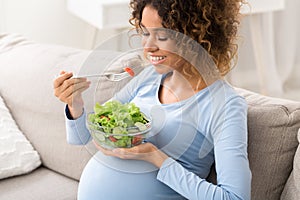 Healthy pregnancy food. African-american girl eating fresh vegetable salad