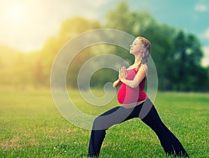 Healthy pregnant woman doing yoga in nature