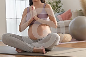 Healthy pregnant woman exercising and doing prenatal yoga, meditation, working out, yoga, pregnancy concept