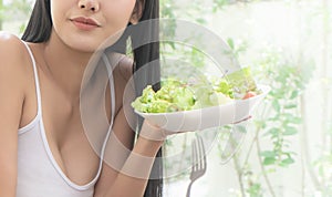 Healthy pretty young woman eating green salad for healthy lifestyle food concept, Asian healthy woman is holding a plate of