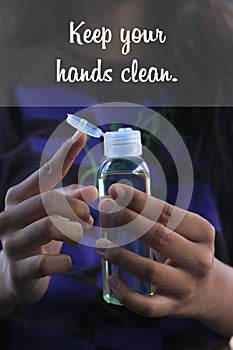 Healthy quote - Keep your hands clean. With hands holding hand sanitizer liquid alcohol to prevent epidemic corona virus covid 19