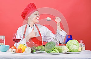 Healthy ration. Woman professional chef hold spoon with raw mushroom. Dieting concept. Girl wear hat and apron try