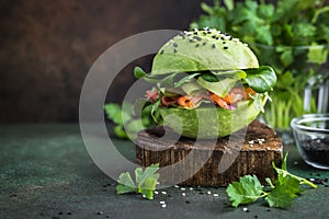healthy raw avocado burger with salted salmon and fresh vegetables. selective focus