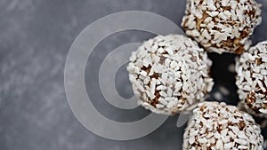 Healthy raw energy balls with cocoa, coconut, sesame, chia on grey background