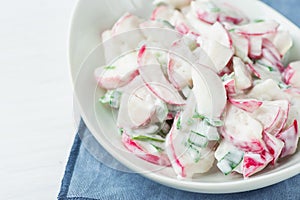 Healthy Red Radish and Green Scallion Onions Salad with Greek Yogurt Dressing in White Serving Bowl on Blue Napkin. Easter Brunch