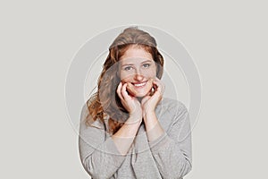Healthy redhead woman looking at camera and smiling on white background
