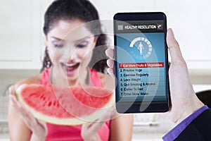 Healthy resolutions app with woman eats watermelon