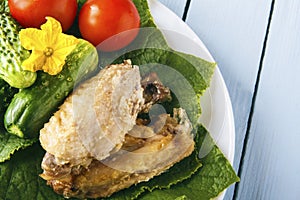 Healthy rustic food from chicken wings and natural organic vegetables. Tomatoes and cucumbers on wooden table. Copy space. Top vie