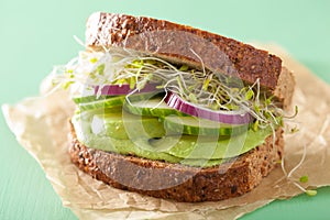 Healthy rye sandwich with avocado cucumber alfalfa sprouts