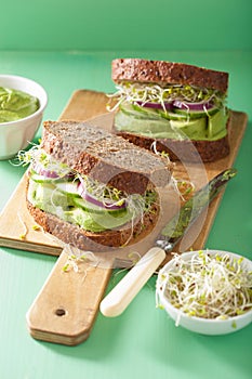 Healthy rye sandwich with avocado cucumber alfalfa sprouts