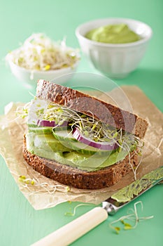 Healthy rye sandwich with avocado cucumber alfalfa sprouts