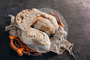 Healthy rye wholegrain bread in a brown Kraft basket on a farmer`s wooden table. Homemade cake