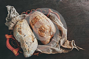 Healthy rye wholegrain bread in a brown Kraft basket on a farmer`s wooden table. Homemade cake