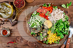 Healthy salad bowl with chicken, mushrooms, corn, cucumbers, sweet pepper and mix salad