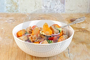 Healthy salad bowl with cuscus, chicken, tangerine and sesame seeds