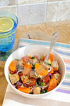 Healthy salad bowl with cuscus, chicken, tangerine and sesame seeds