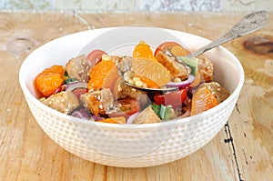 Healthy salad bowl with cuscus, chicken, tangerine and sesame seeds