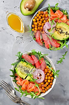 Healthy salad bowl with salmon, grapefruit, spicy chickpeas, avo