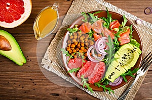 Healthy salad bowl with salmon, grapefruit, spicy chickpeas, avo