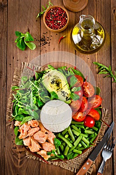 Healthy salad bowl with salmon, rice, tomatoes, avocado, mix sal