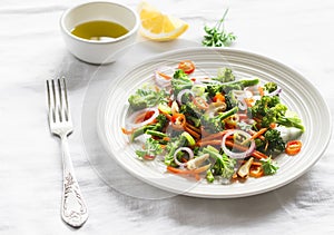 Healthy salad with broccoli and carrots on a white plate