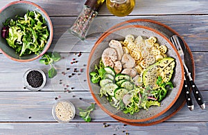Healthy salad with chicken, avocado, cucumber, lettuce, radish and pasta on dark background. Proper nutrition. Dietary menu. Dinn