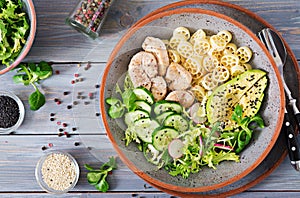 Healthy salad with chicken, avocado, cucumber, lettuce, radish and pasta on dark background. Proper nutrition. Dietary menu. Dinn