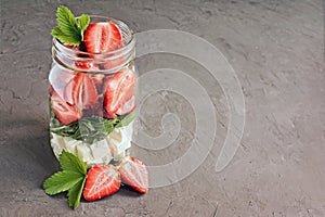 Healthy salad dish with fresh strawberry, arugula and soft cheese in glass jar