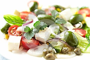 Healthy Salad with Feta Cheese, Green Olives, Baby Spinach, Cucumber, Cherry Tomatoes and Capers. Bright background