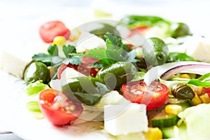 Healthy Salad with Feta Cheese, Green Olives, Baby Spinach, Cucumber, Cherry Tomatoes and Capers. Bright background