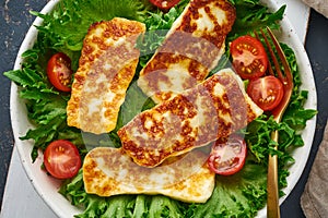 Healthy salad with fried halloumi and tomatoes, closeup top view, keto ketogenic diet