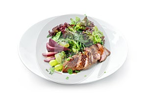 Healthy salad with medium rare beef steak, pear, grapes, lettuce, arugula, and sauce in plate isolated on white background.