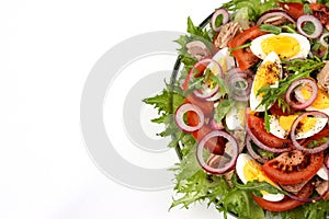 Healthy salad of organic salad with canned tuna, tomatoes, chicken eggs, arugula, red onion and microgreens