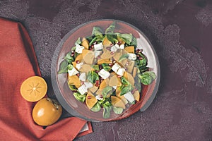 Healthy salad with persimmon, doucette lambs-lettuce, cornsalad, feld salad and feta cheese. Fitness food, superfoods vitamin